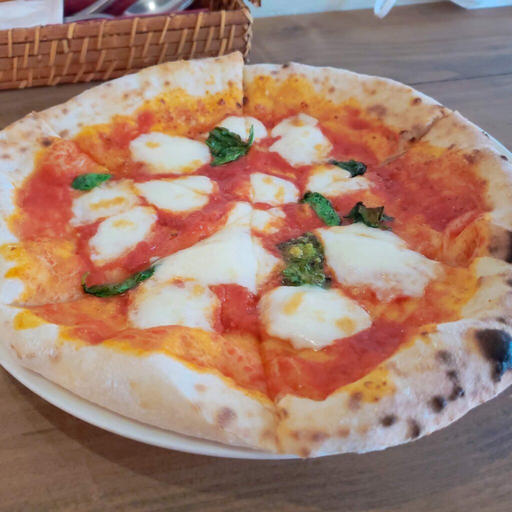白い皿に載せられたトラットリアミノリのピザ