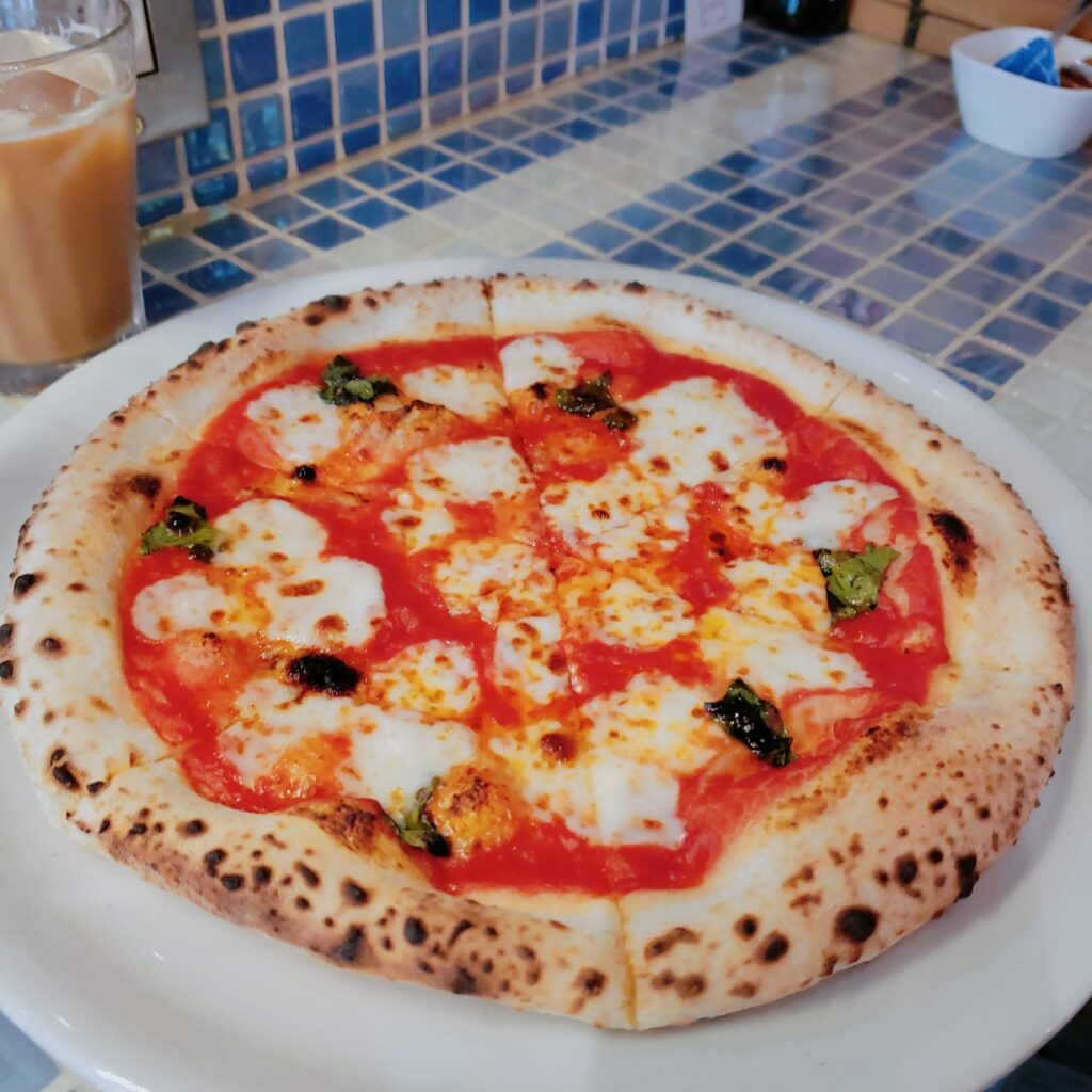 白いお皿に載せられたアルベリのピザ